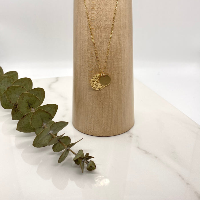 Image shows a 14-K gold-filled necklace with two gold-filled coin charms. One charm is engraved with the letter J and theh other charm is a hammered gold-filled coin.