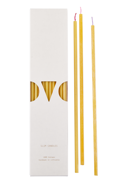 Thin and fine candle with different colored wicks. Package of candles next to three candles that lay outside of the packaging.