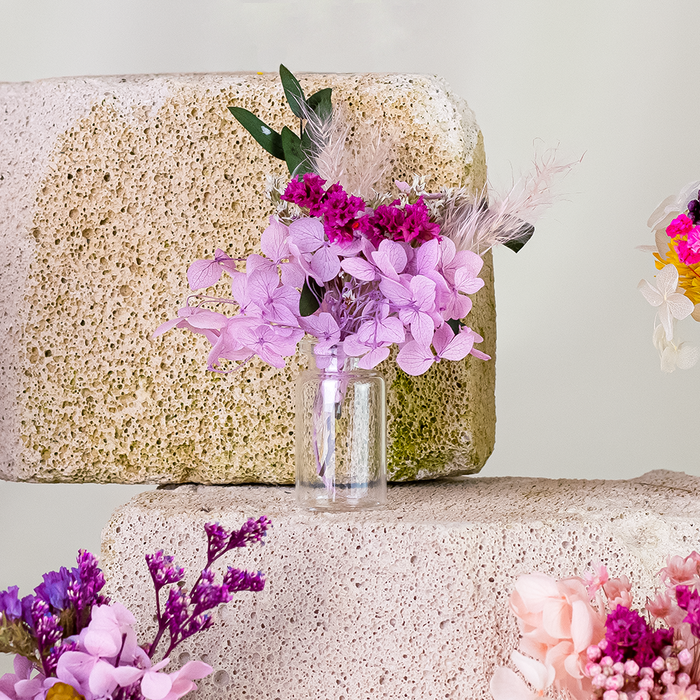 Mini bouquets of dried purple flowers in delicate glass vase.