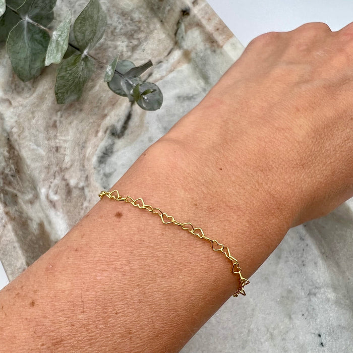 14-K gold-filled tiny heart necklace worn on wrist.