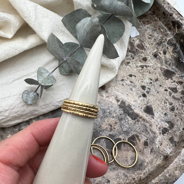 Four 14K gold-filled wire rings displayed on a porcelain cone.