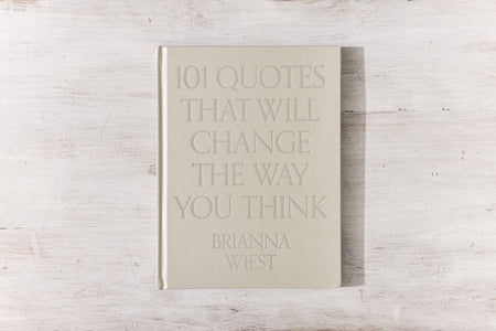 A hardcover coffee table book with a beige linen cover and gloss pigment foil, featuring 101 quotes by Brianna Wiest that will change the way you think.