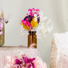 Mini bouquets of dried yellow, white, pink, and purple flowers in delicate glass vase.