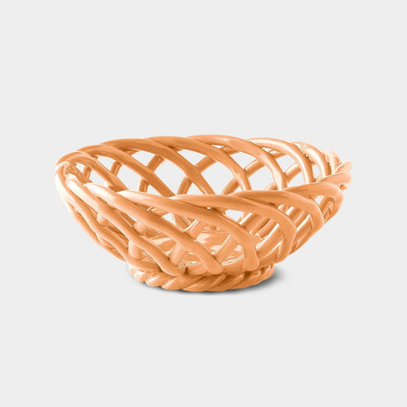 A small, pink ceramic basket with a geometric pattern and a glossy finish.