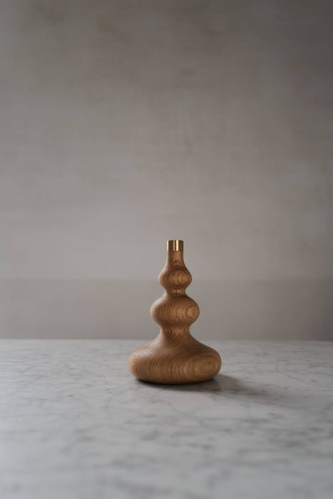 Oiled oak candle stick holder with brass detail.