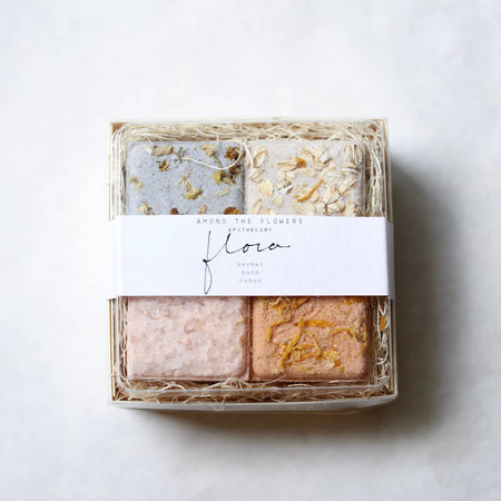 Box of four soap bars with decorative elements on a light background