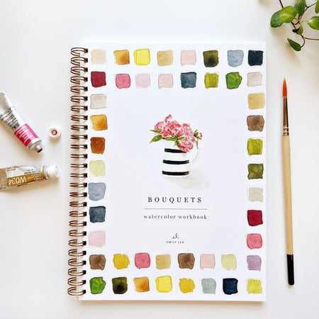 A watercolor workbook titled 'Bouquets' with colorful square watercolor illustrations and a floral bouquet illustration on the cover, alongside watercolor paints and a paintbrush.