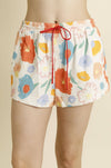 Colorful floral shorts with a red drawstring on a beige background