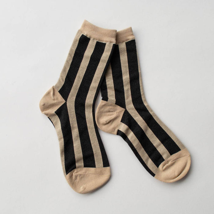Pair of black and beige striped socks on a light gray background