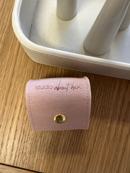 Rose colored small Ring Pouch to fit your ring collection. Engraved with "Studio About Her" logo. Closes with a push button.