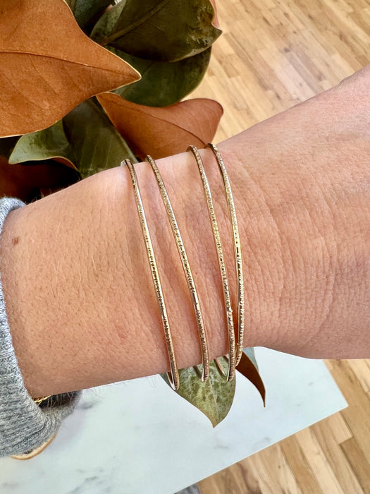 14k gold-filled hammered bangles. Four stacked on wrist.