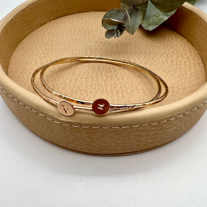 Personalized 14k gold-filled bangle bracelet with personalized charm. Each charm is distinctively stamped with one letter.