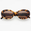 Tortoiseshell sunglasses with brown lenses on a white background