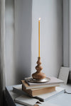 Thin and fine candle in wooden candle holder.