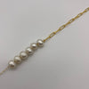 14k gold-filled chain bracelet adorned by six freshwater pearls shown in a close up behind a white background.